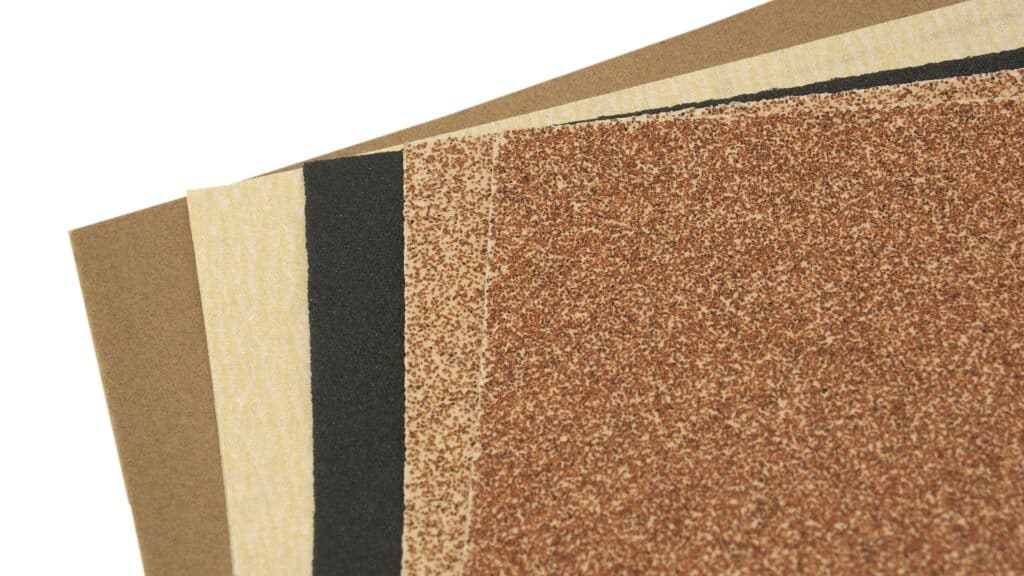 Flere forskellige stykker sandpapir, der kan skelnes ved deres farve.
