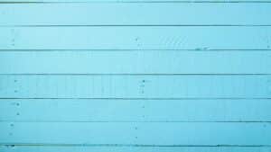 Et blåt plankgulv med små indrykninger synlig.