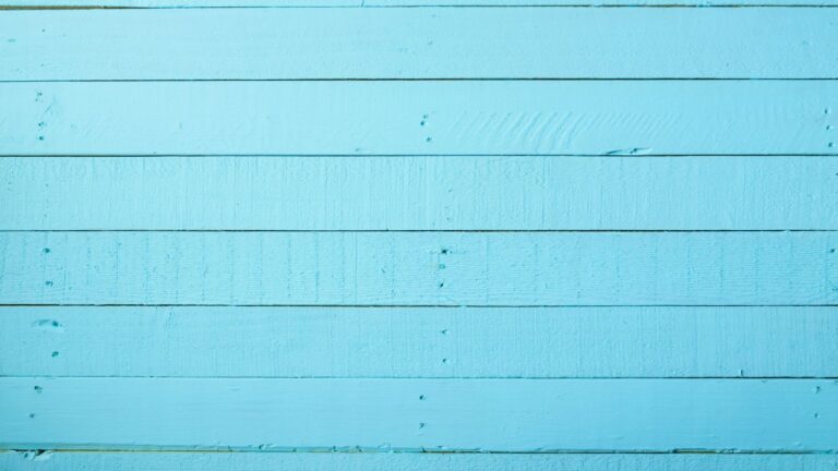 Et blåt plankgulv med små indrykninger synlig.