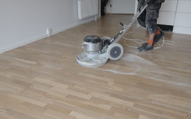 Processen med professionel gulvafslibning ved hjælp af en moderne Bona gulvsliber - en indblik i en gulvmands arbejdsproces.